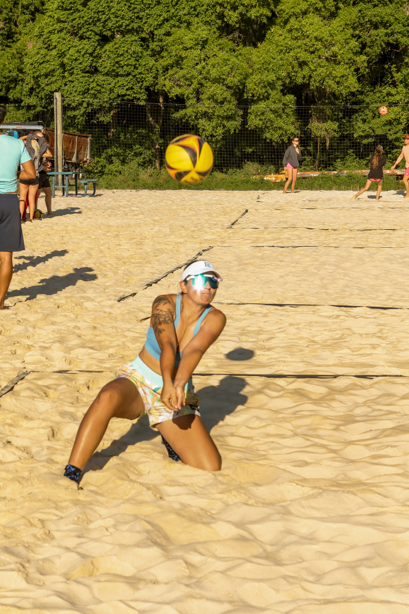 Female player in defensive volleyball position on sand court