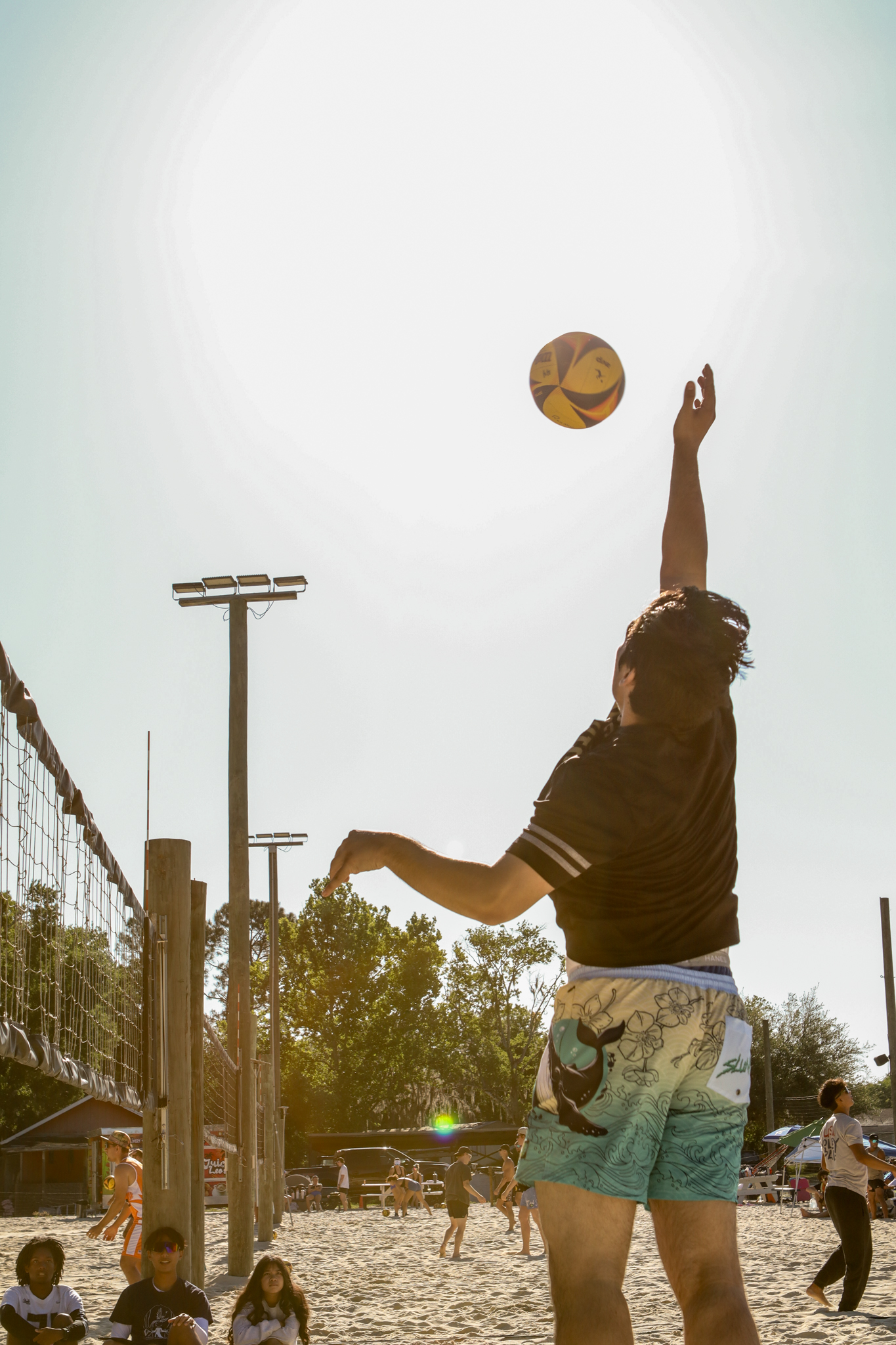 Beach volleyball player serving during tournament