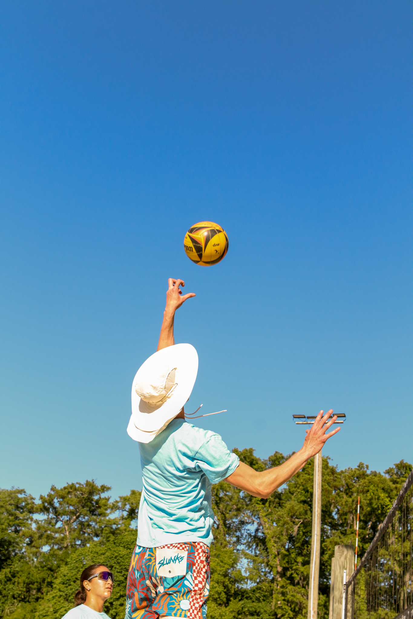 Player spiking volleyball at tournament